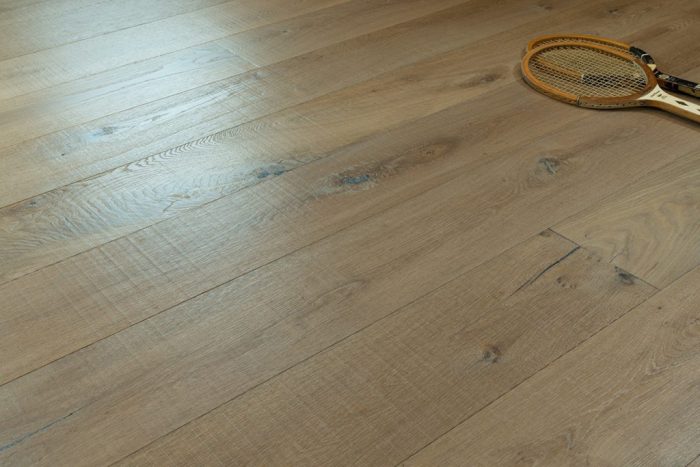 close up of hardwood floor with two old wooden tennis racquets
