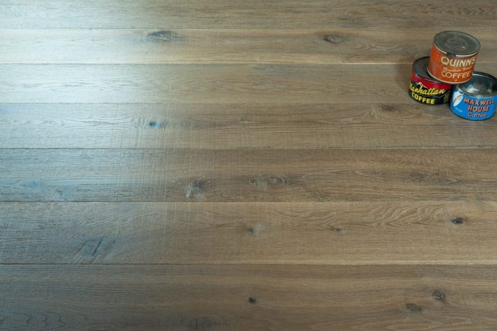 close up of hardwood floor with three vintage coffee cans