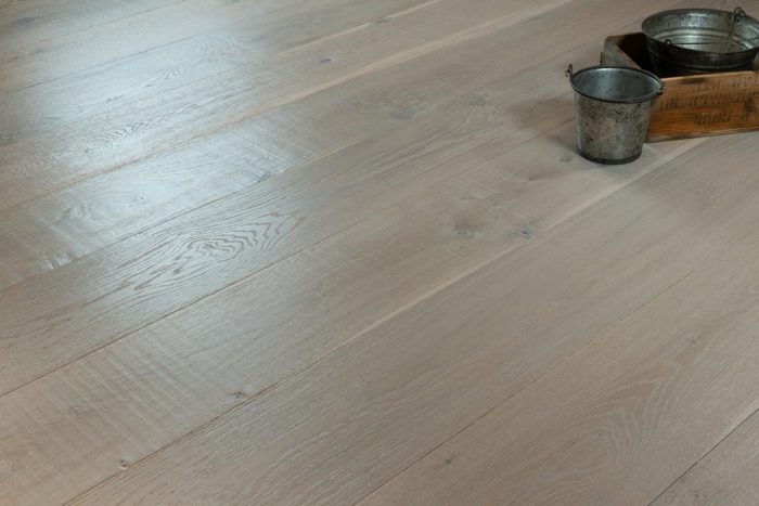 close up of hardwood floor with two metal buckets and a wooden box