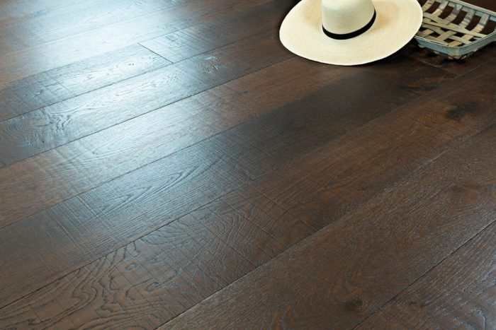 close up of hardwood floor with white, large brimmed hat