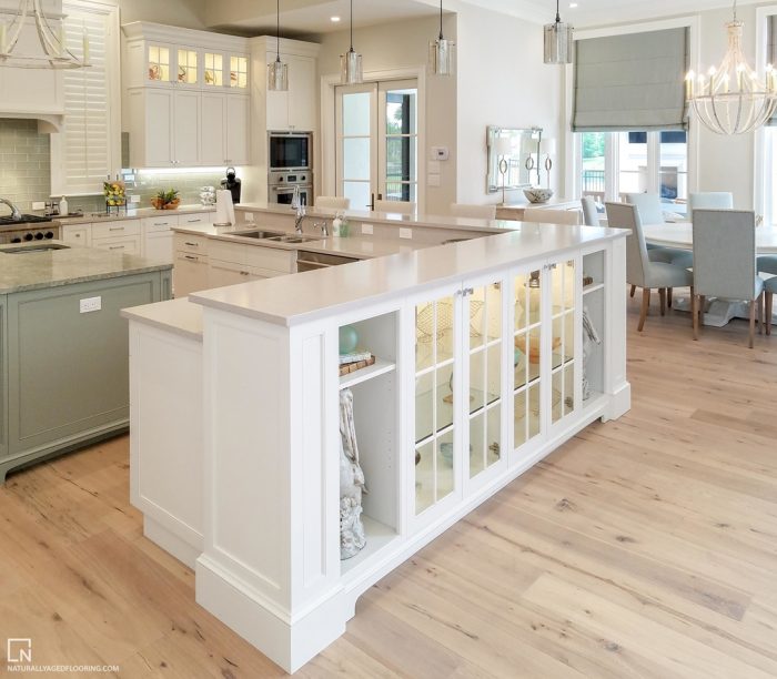 hardwood floors in full kitchen with breakfast nook in background