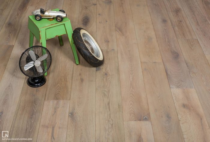 hardwood floor with green table, toy car, table fan, and tricycle tire