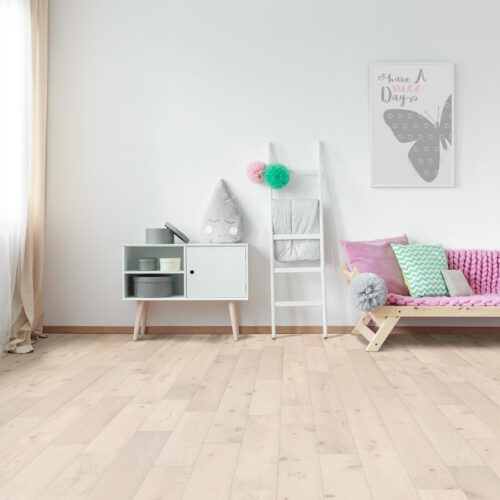 hardwood floors in room with a futon, shelves, cabinet table, and art work