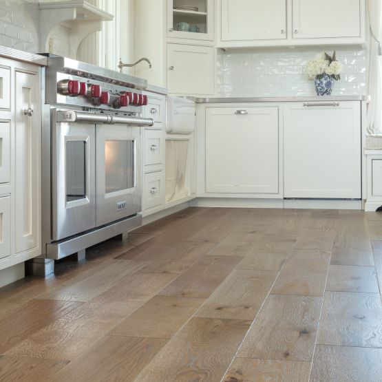 hardwood flooring in white kitchen with cabinets and a stove