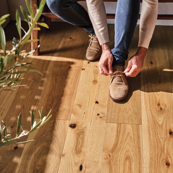 hardwood flooring with a close up of a man tying his shoes