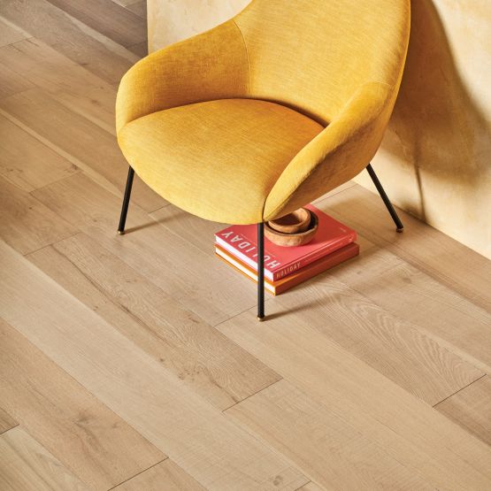 hardwood flooring and a yellow chair with pink books under it