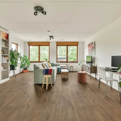 Dover dark espresso waterproof luxury vinyl plank flooring in a bright living room with bookshelves and chair