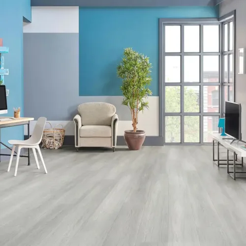 Quincy soft cool-grey waterproof luxury vinyl plank flooring in a bright modern living room with blue accent walls